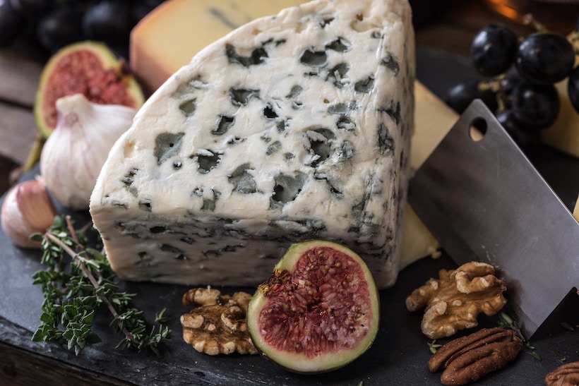 Cheese, fruit, and nuts on a cutting board