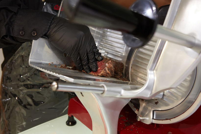 MEat slicing machine with a man and gloves