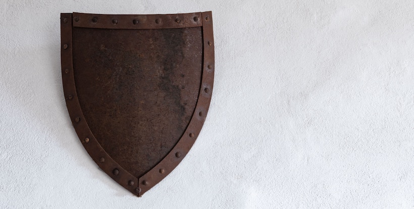 Rusted iron shield hanging on a wall