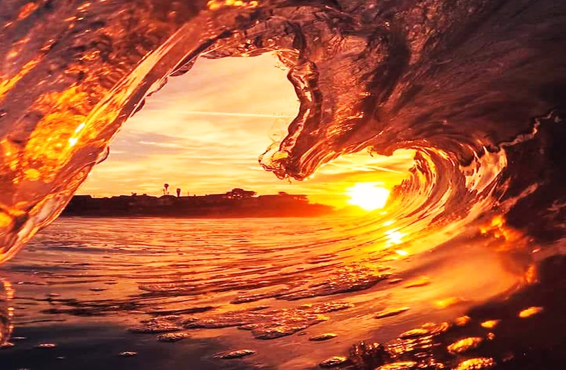 Wave frozen in the shape of a heart with beach in background