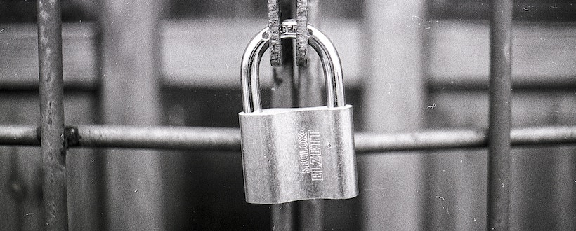 Padlock closed and protecting a gate
