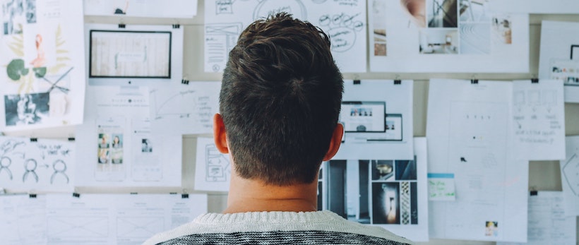 A man stares at a whiteboard and thinks