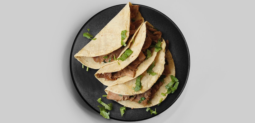 Tacos on a plate with cilantro and steak