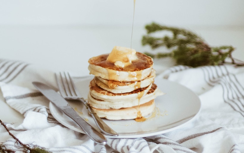 Honey drizzling on a stack on pancakes