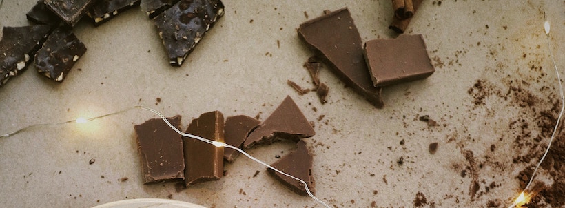 Milk chocolate pieces plus dark chocolate with nuts on a table