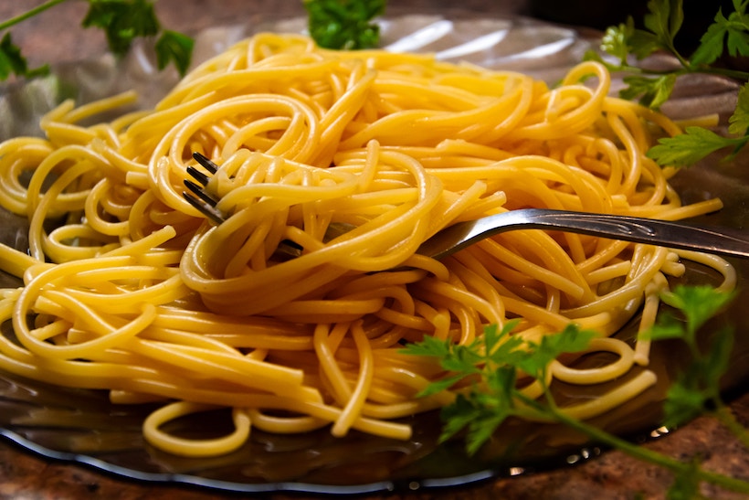 Spaghetti on a plate with fork and herbs