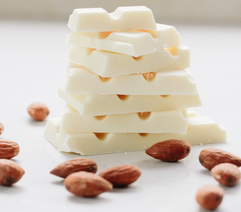 White chocolate squares and almonds scattered around