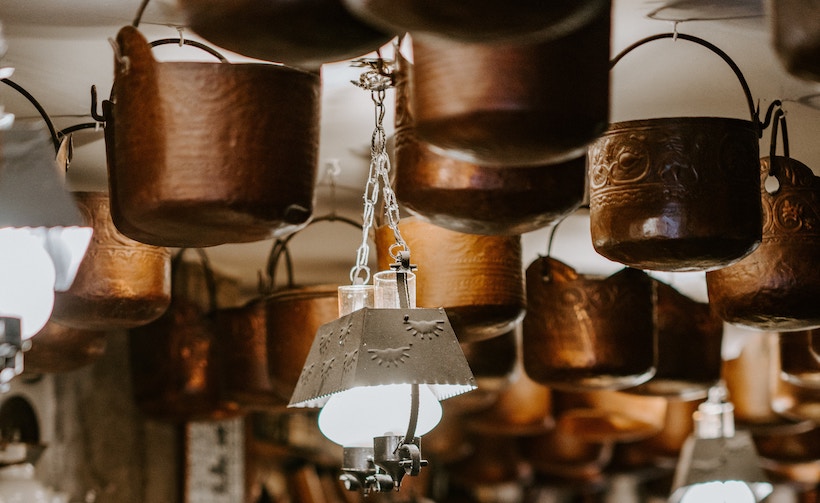 Copper cookware hanging from ceiling in kitchen