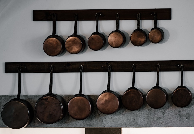 Copper pots and pans hanging on a rack