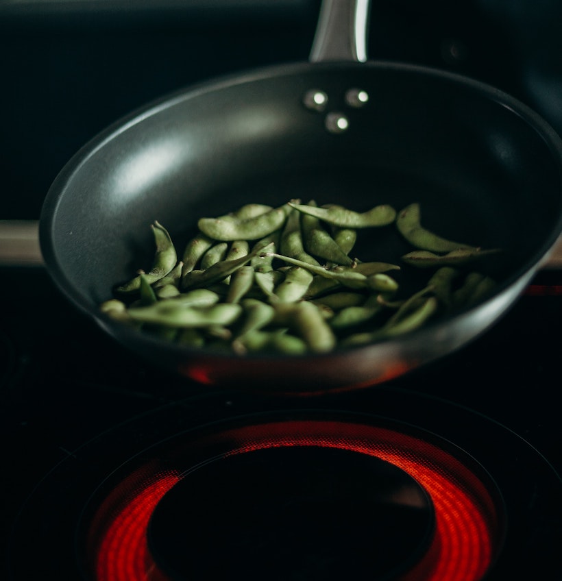 Green beans in a pan over a halogen burner