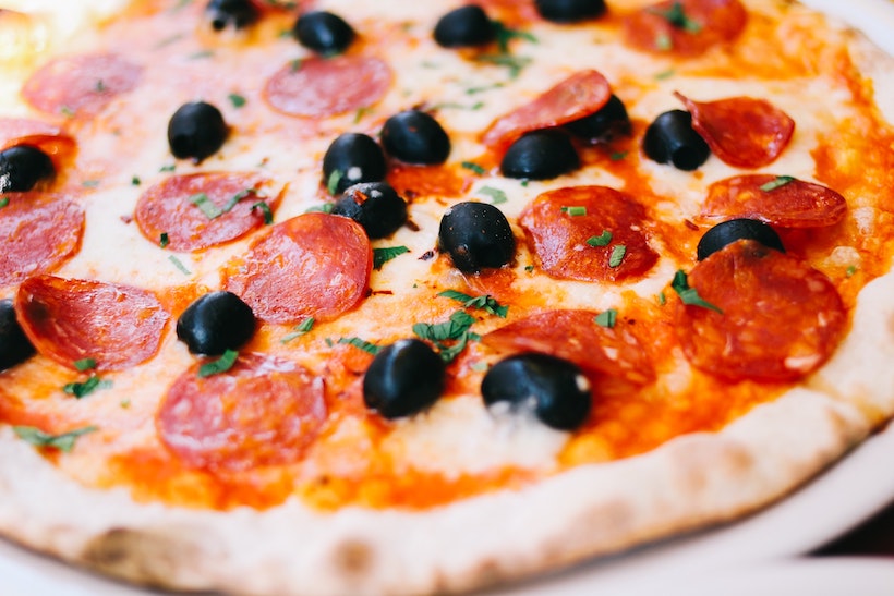 Shallow depth of field picture of pepperoni pizza with olives