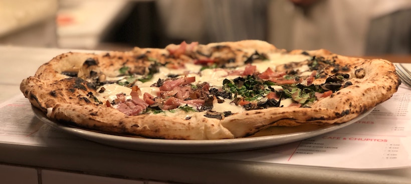 Pizza with ham and greens on a pizza menu