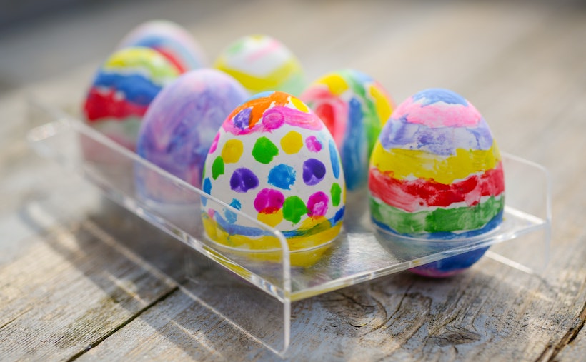 Assorted decorated Easter eggs in a plastic tray