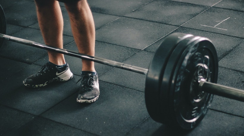 A man prepares to deadlift a barbell