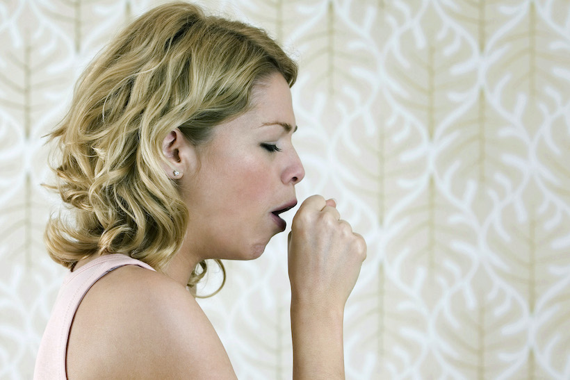 Lady coughing into her hand