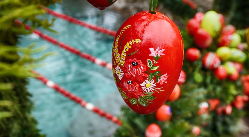 A red Easter egg on a tree with flowers