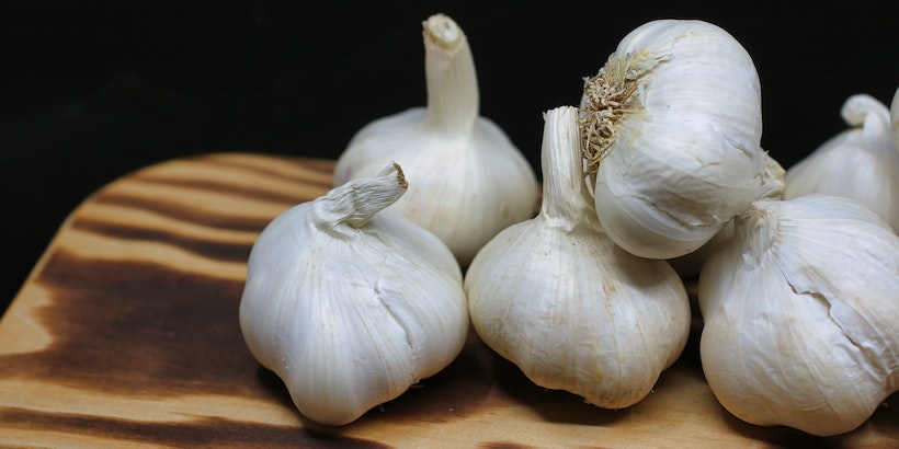 Garlic bulbs on a wood cutting baord