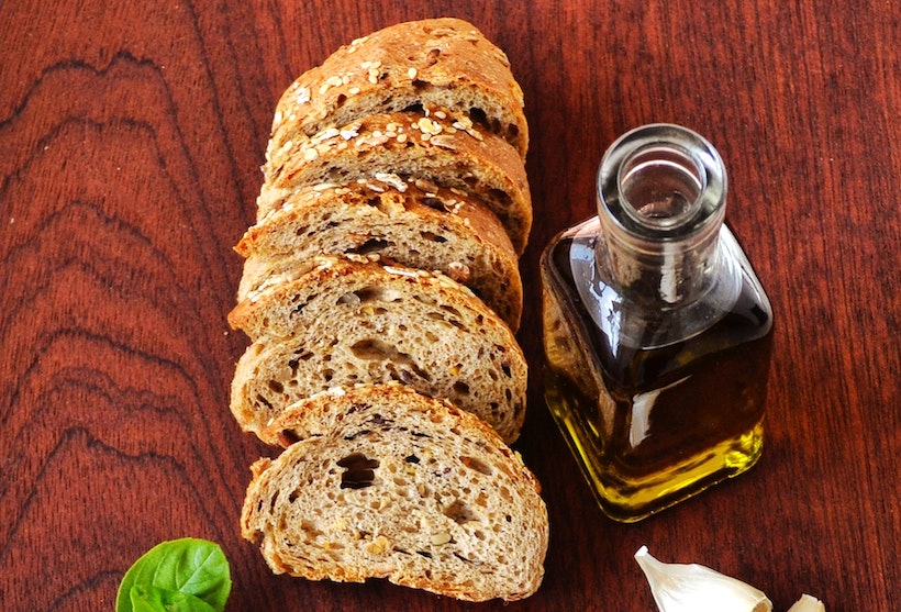 Table with basil, garlic, bread, and olive oil