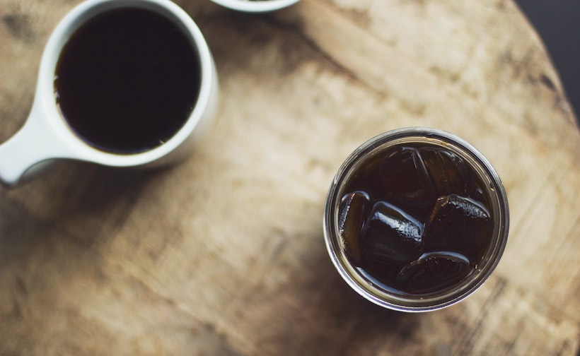 Cold brew cup next to hot brew on wood