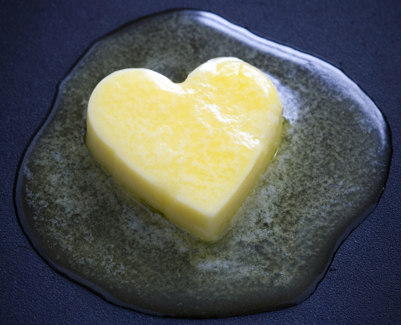 a heart shaped butter pat melting on a non-stick surface