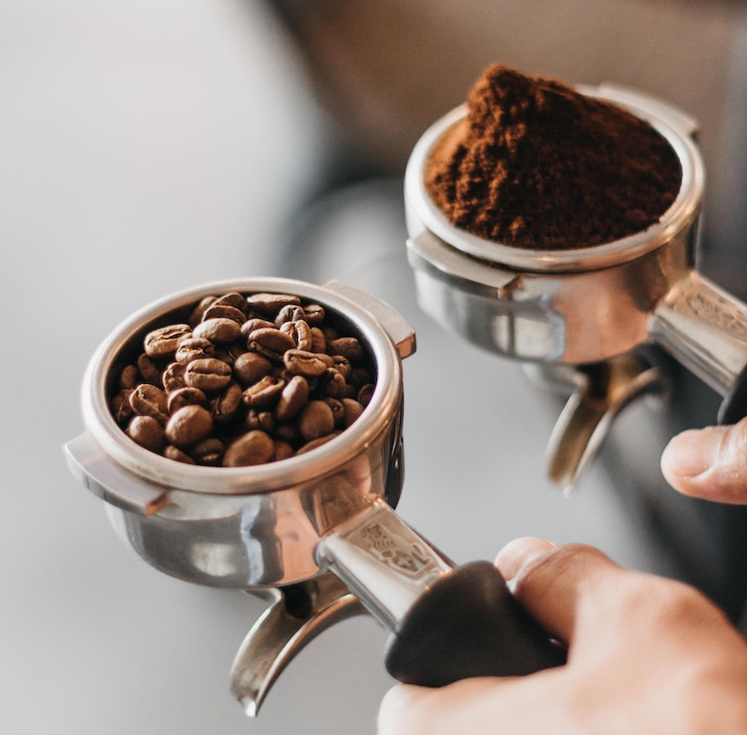 2 espresso portafilters, one with ground and one with beans