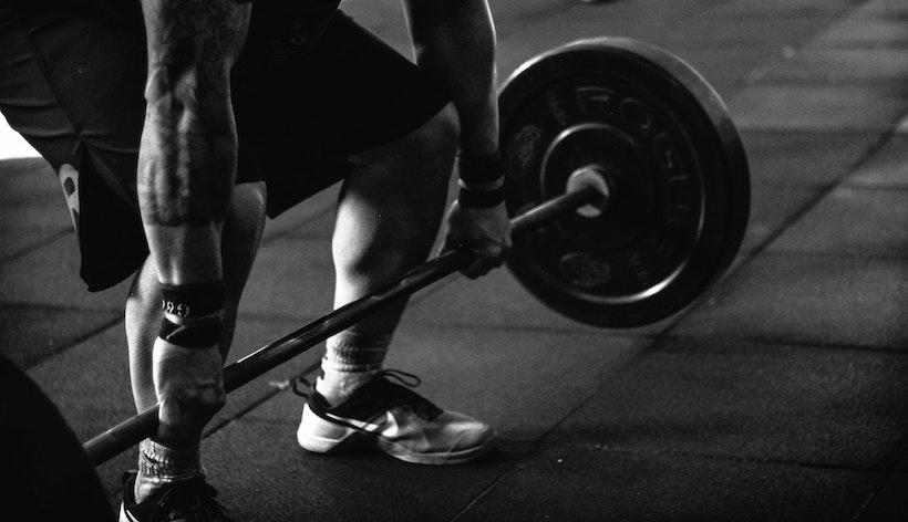 Strong man about to lift a barbell in a deadlift