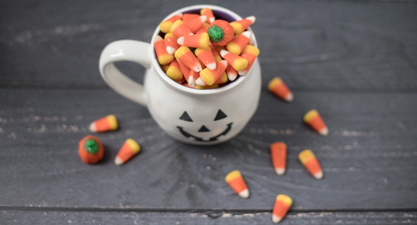 Halloween theme cup with candy corn inside.