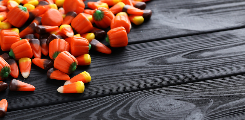 Halloween candy corns on black wooden background