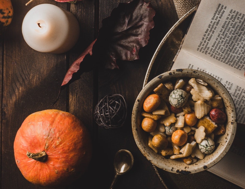 Pumpkin near candle and bowl