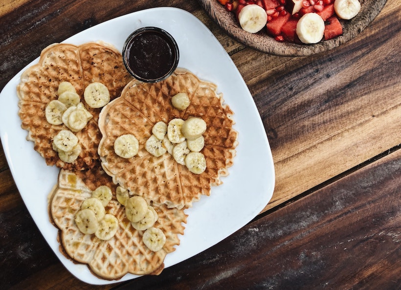 Waffles con los plátanos en la parte superior