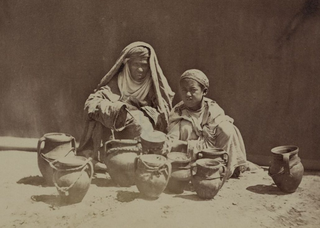 An older lady and young boy with jugs likely containing yogurt