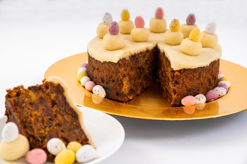 Slice of simnel cake taken from a whole, with marzipan