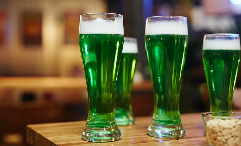 Green beers on a table with peanuts in a glass