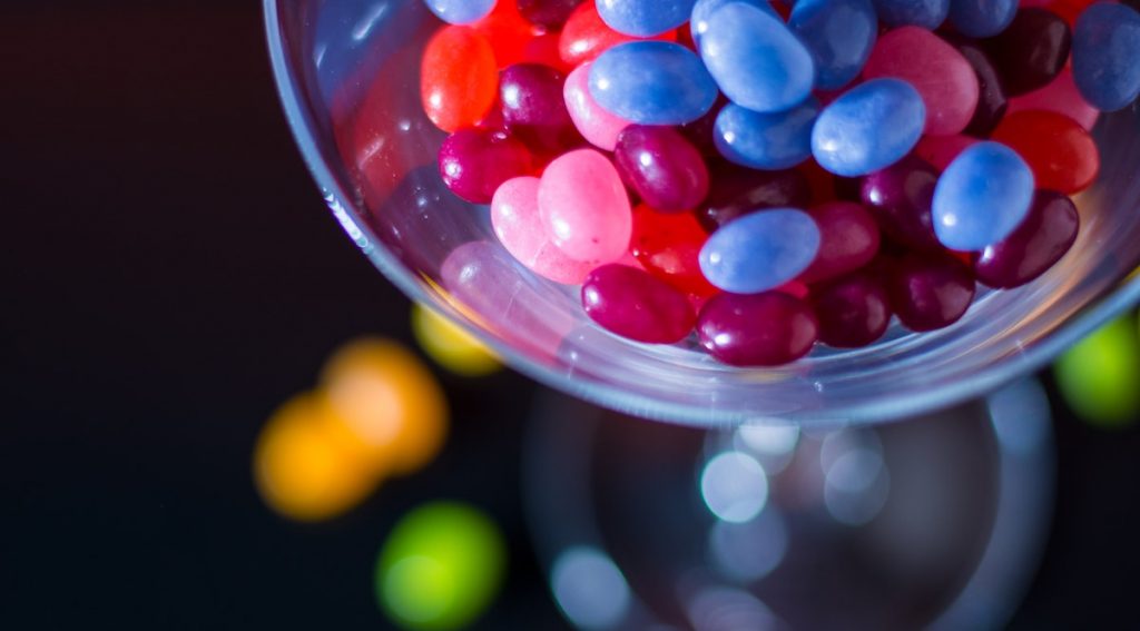 Jelly beans in a glass bowl with some spilled out