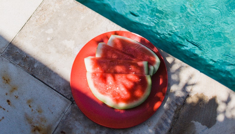 Watermelon on the edge of a pool